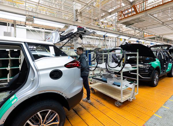 A man inspects a car on the production line