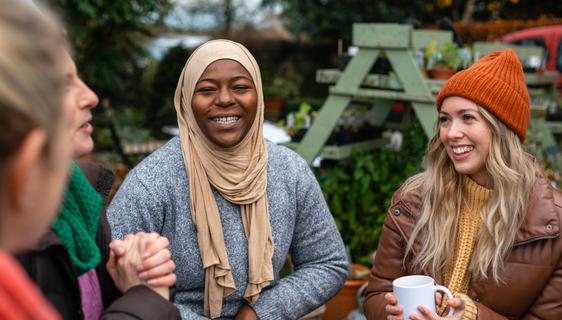 A group of women sat in a garden, talking