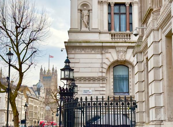 Downing Street sign with Westminster in background