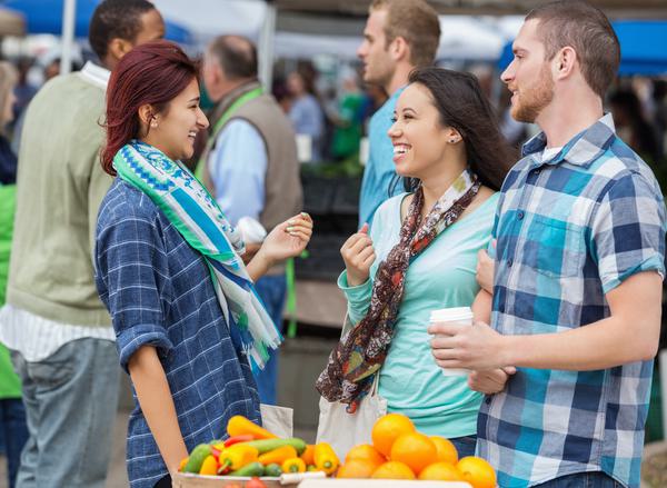 A group of people stood talking in a food market