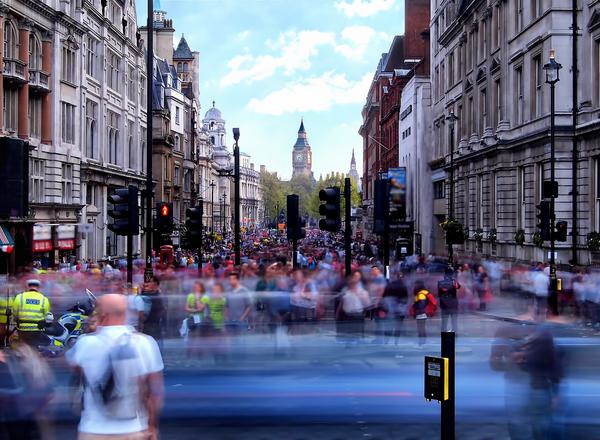 A blur of people and traffic with Trafalgar Square, London in the background