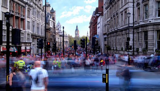 A blur of people and traffic with Trafalgar Square, London in the background